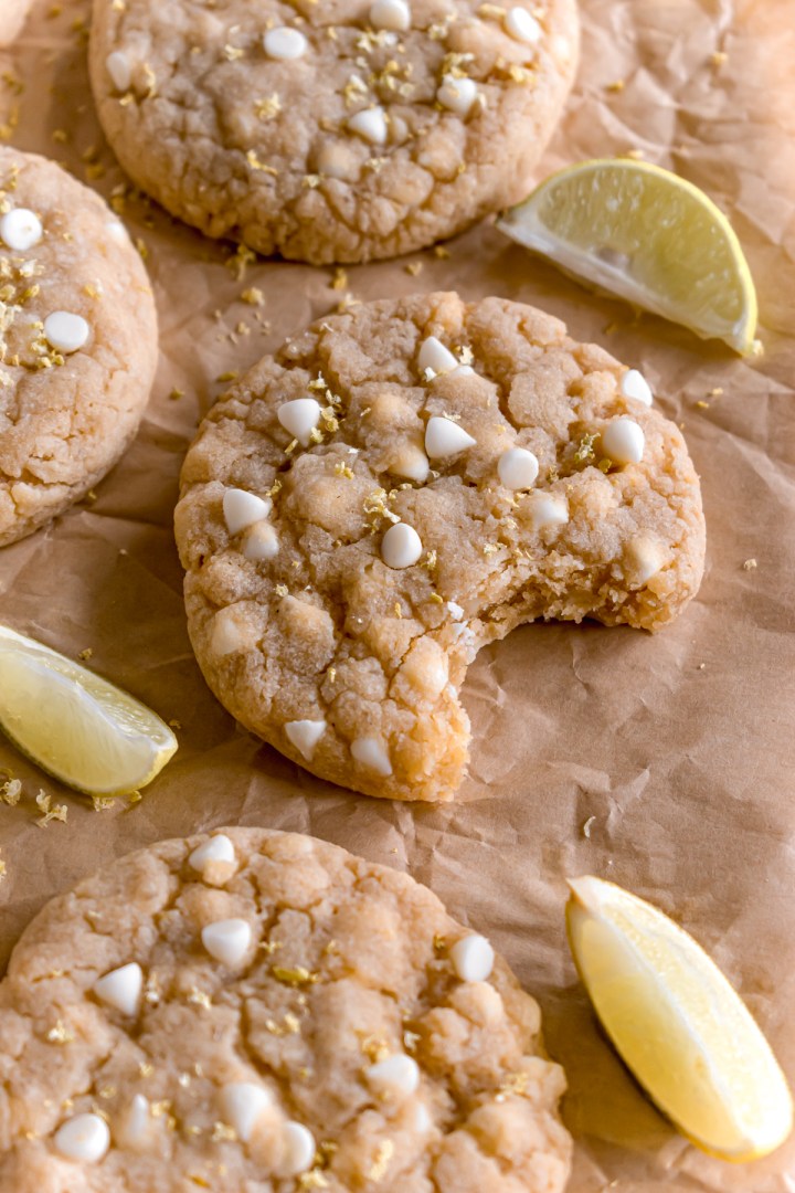 lemon and white chocolate cookies on a parchment paper with a bite taken