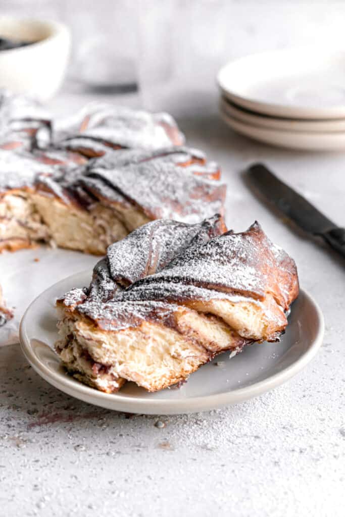 Baked Blueberry jam cream cheese star bread slice on a plate dusted with powdered sugar