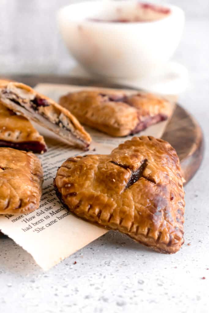 Heart shaped mini blueberry pies on a wooden board