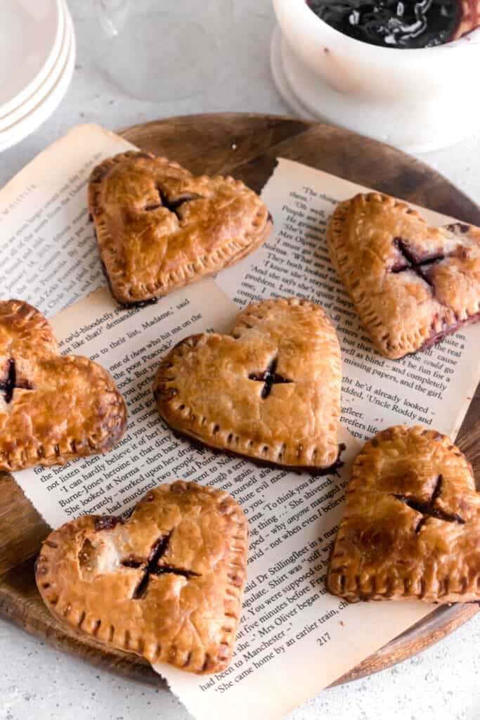 Heart shaped mini blueberry pies on a wooden board