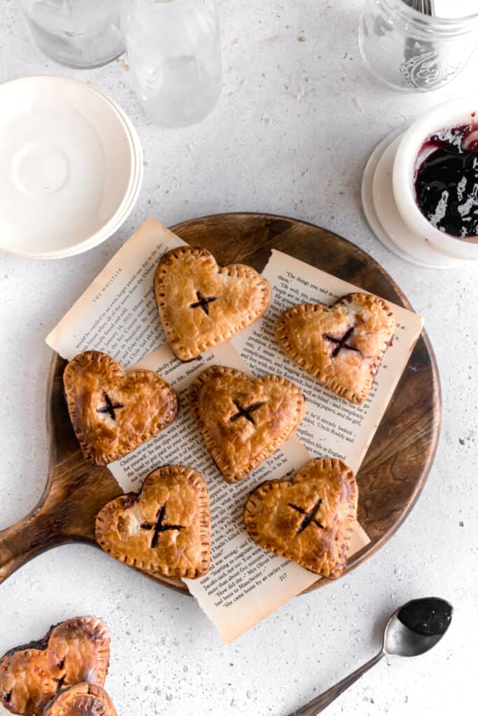 Heart shaped mini blueberry pies on a wooden board
