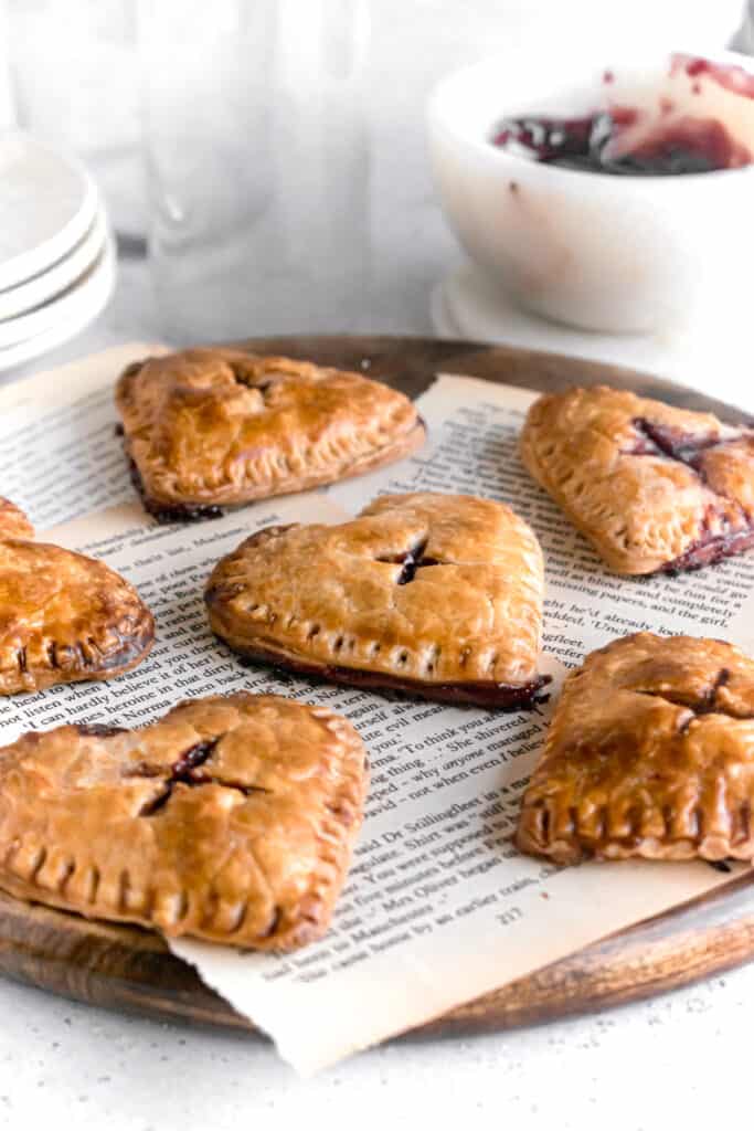 Heart shaped mini blueberry pies on a wooden board
